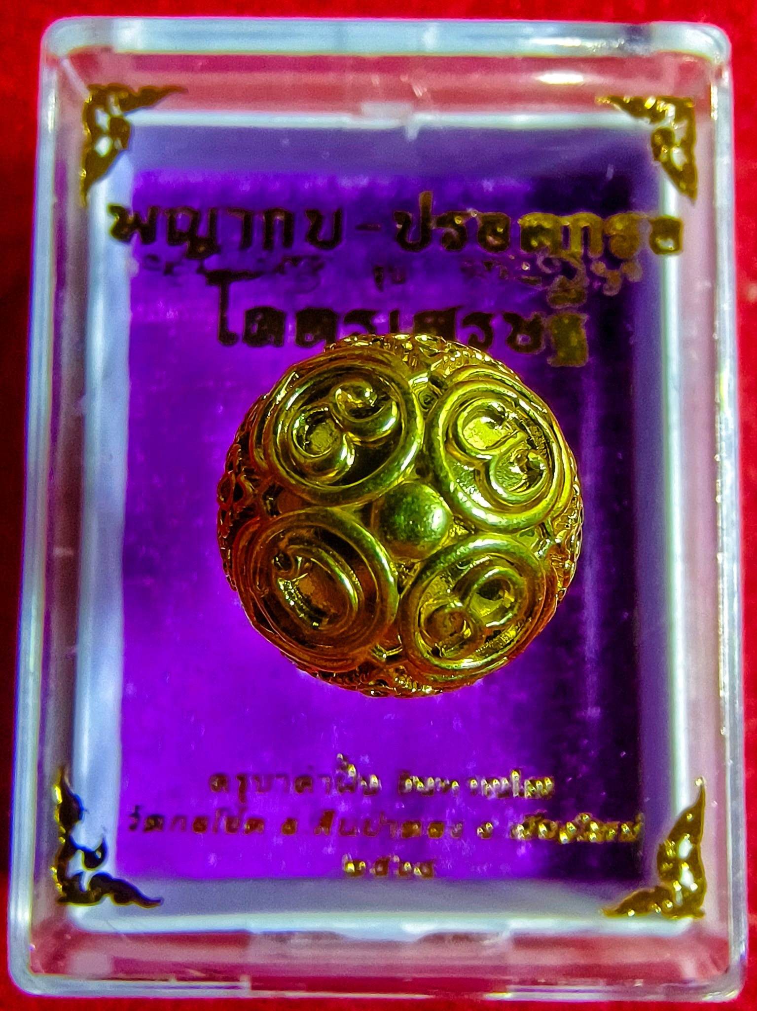 Thai Blessing Co gold ornate amulet in display case on purple background ancient mercury spirit orb feng shui talisman