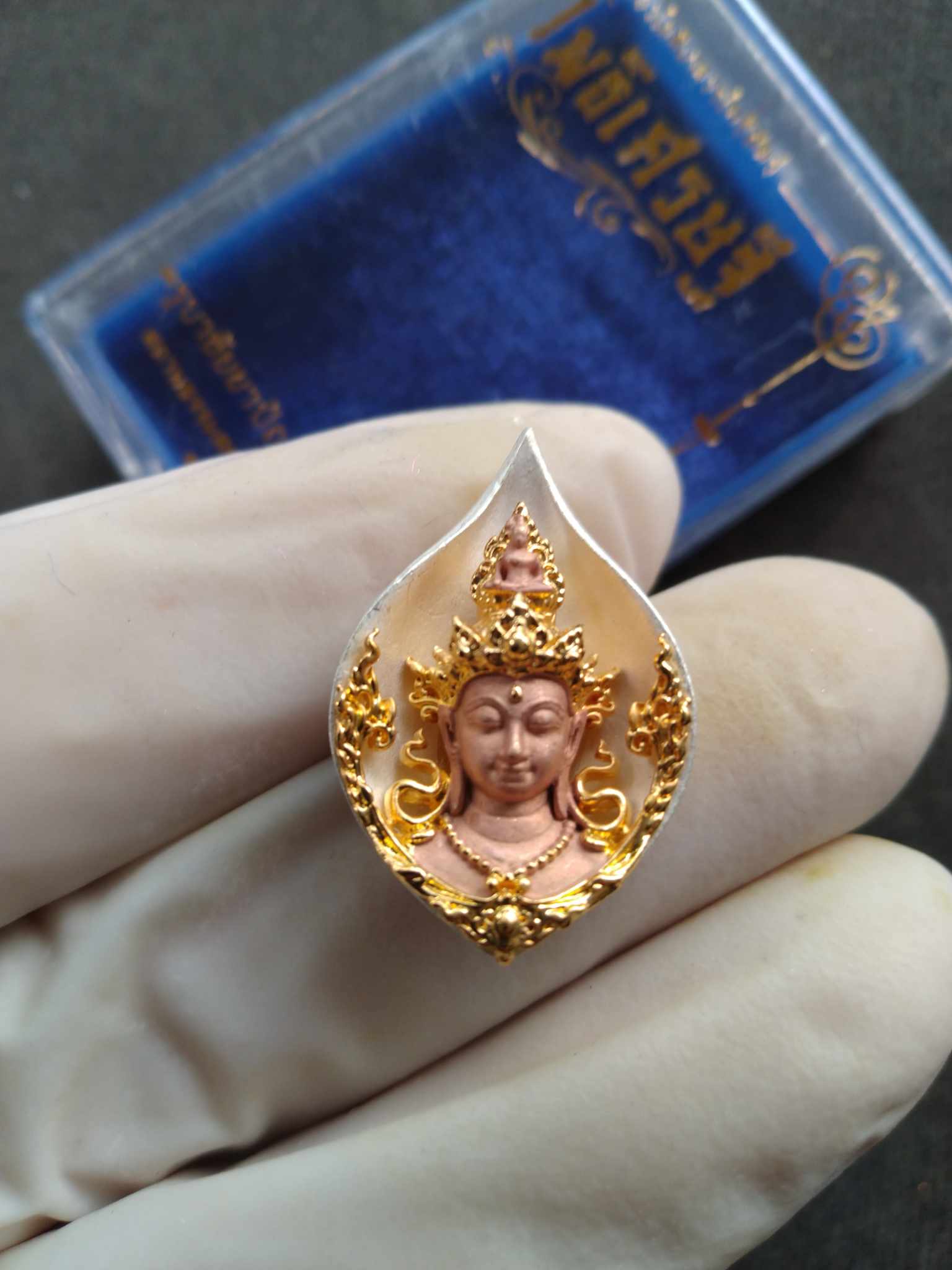 Thai Blessing Co Avalokiteshvara Bodhisattva amulet teardrop pendant with gold filigree and rose metal deity held in gloved hand