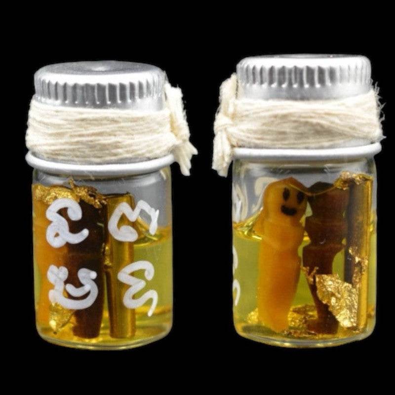 Two small Thai charm vials with metal caps twine white script gold leaf and tiny figurine buy Thai spiritual charm for romance