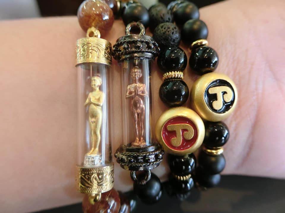 Collection of Thai amulets for protection and wealth in gold and black bracelets