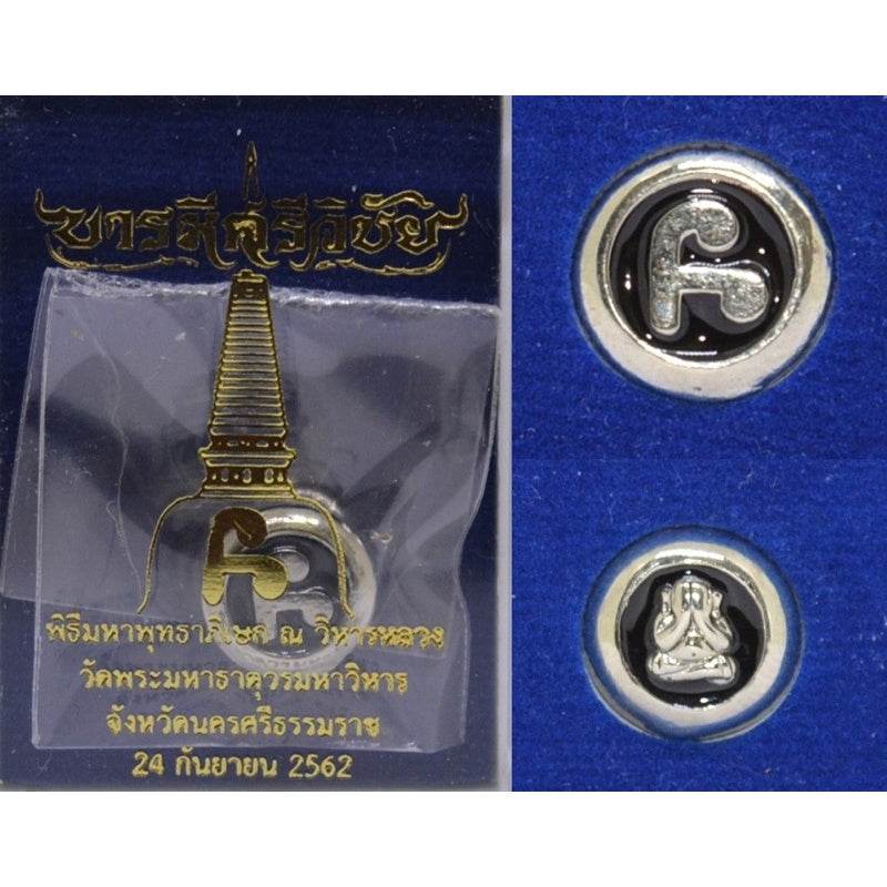 Thai amulet for protection and wealth featuring intricate designs in a display package