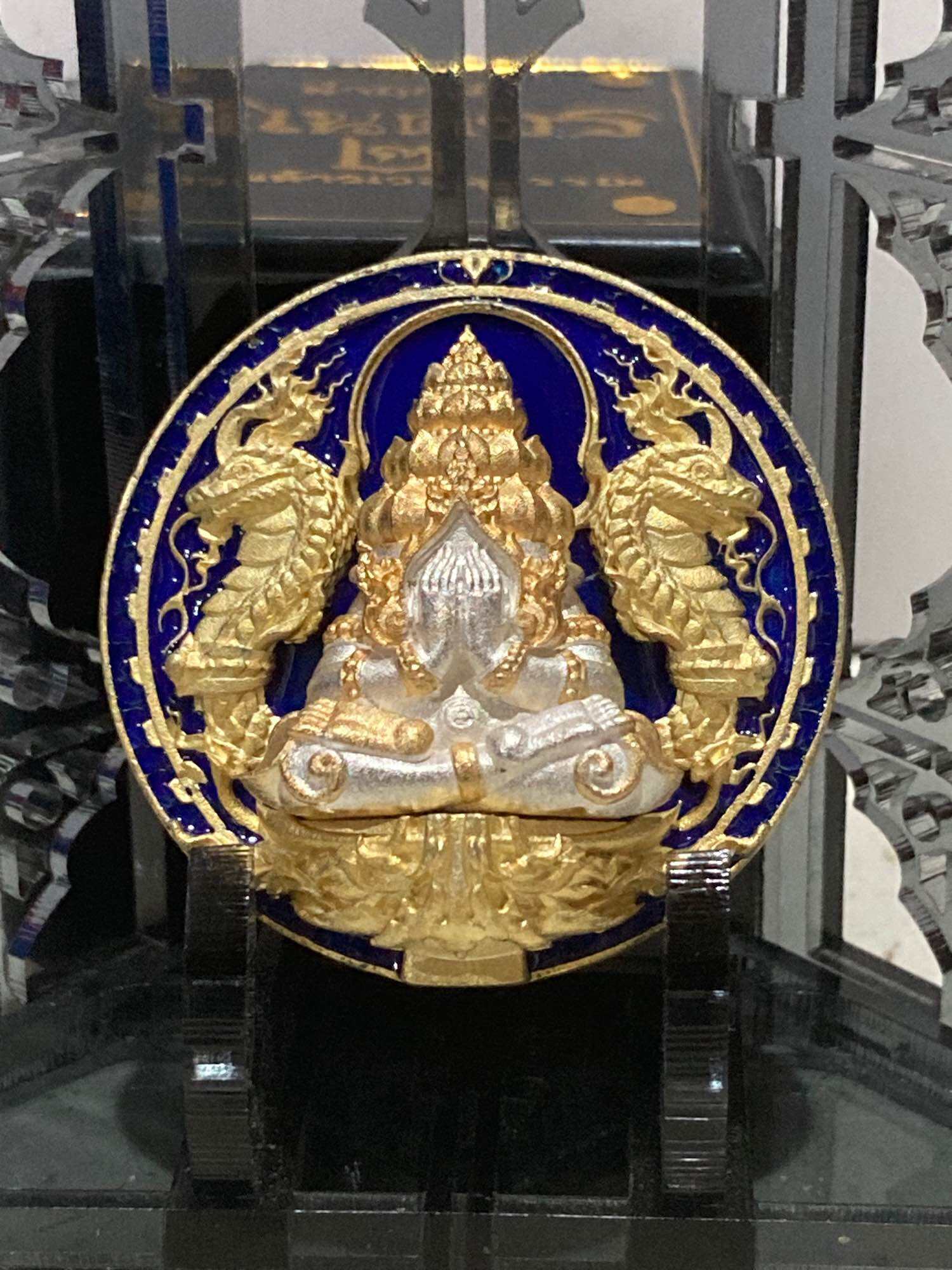 Thai amulet for wealth and protection featuring intricate gold and silver details with dragon embellishments