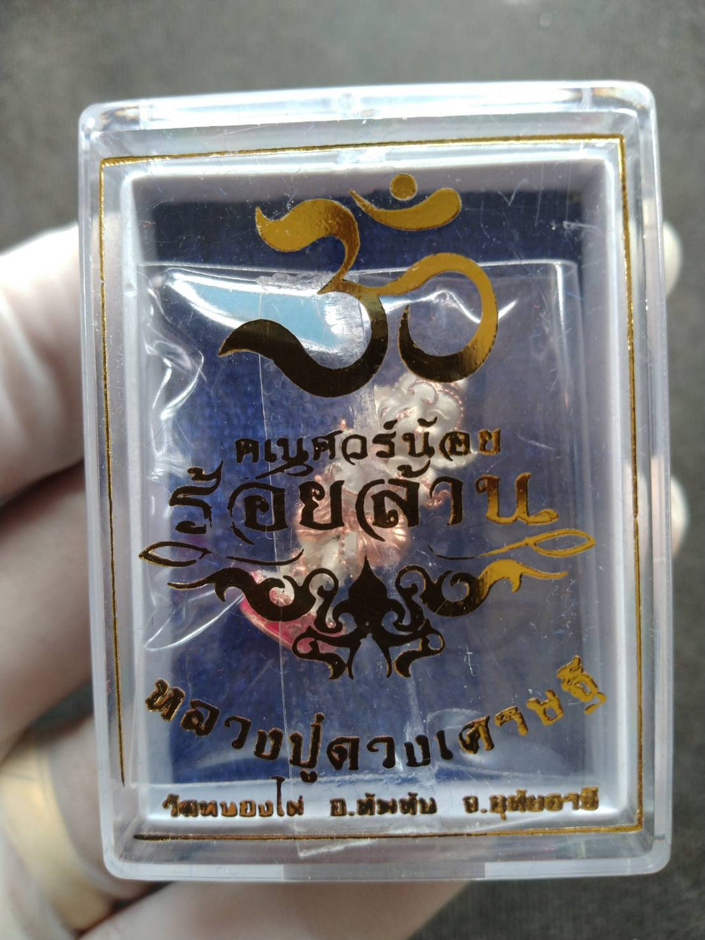 Ganesh Noi amulet Thailand in clear plastic display case with gold Om symbol and Thai script