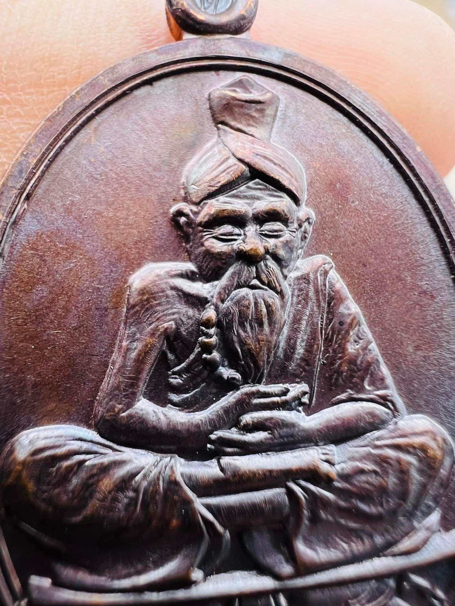 Bronze Thai seated sage amulet with detailed beard and turban close up Great Ruesi amulet first edition