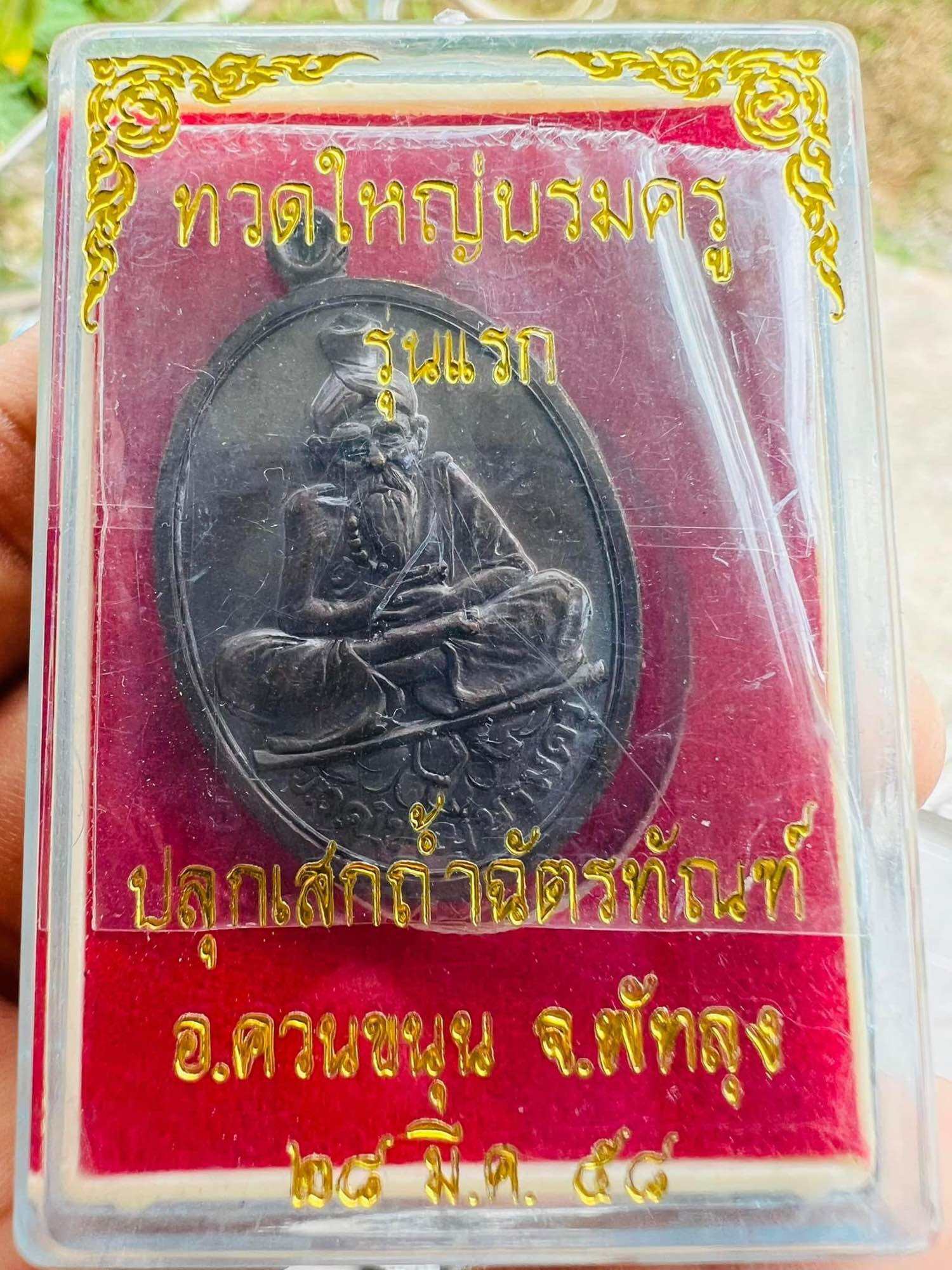Great Ruesi amulet first edition Thai Blessing Co oval metal amulet in clear case with red velvet background