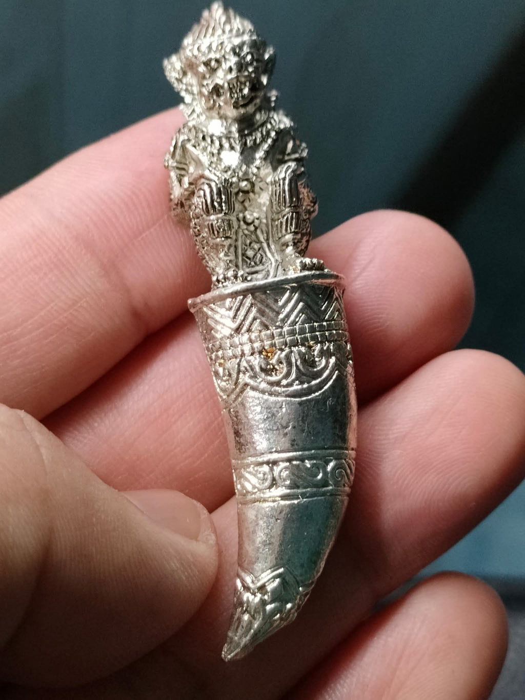 Thai Blessing Co silver amulet pendant Hanuman Sitting on Fangs detailed engraved fang charm held between fingers