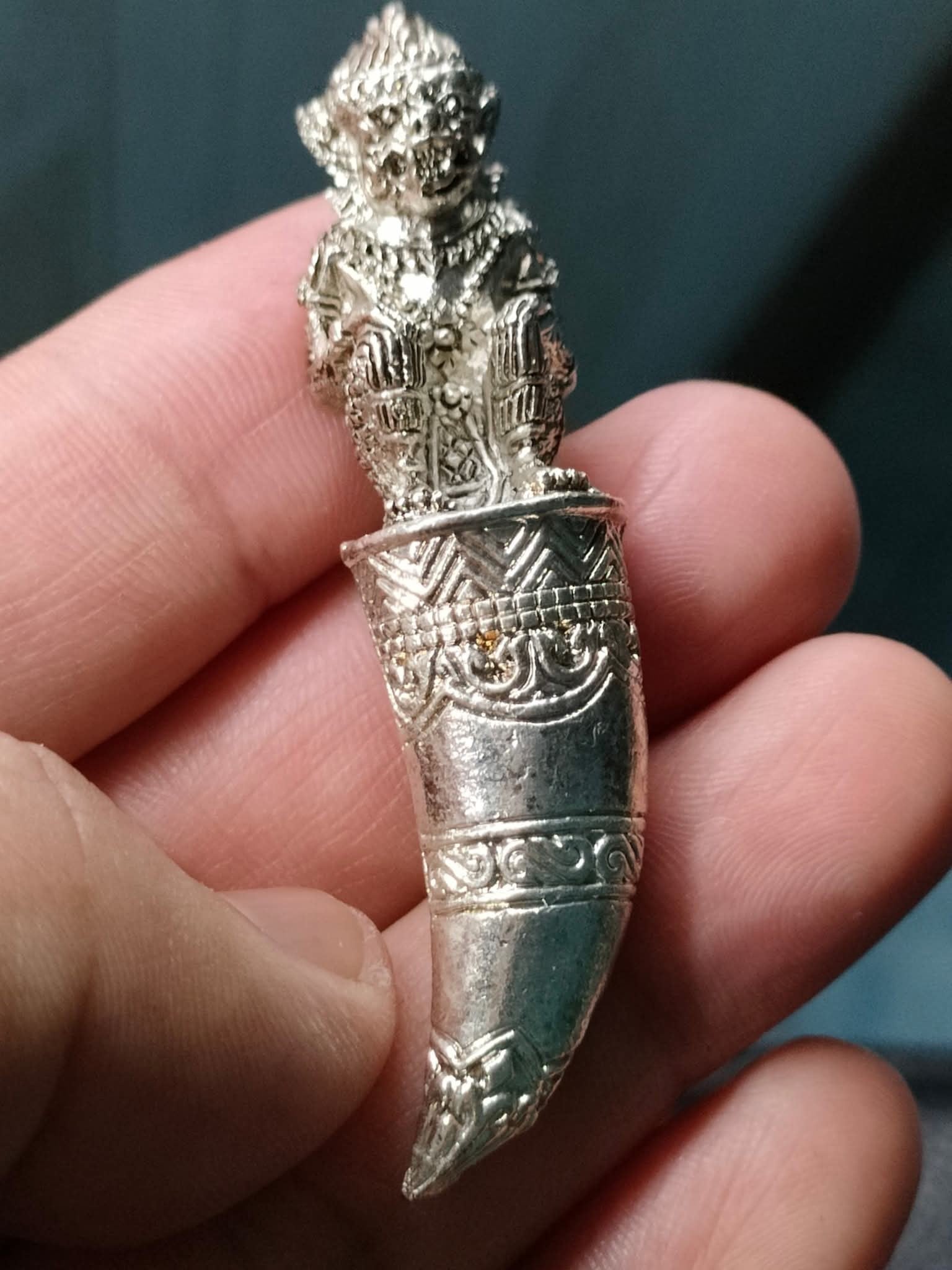 Thai Blessing Co silver amulet pendant Hanuman Sitting on Fangs detailed engraved fang charm held between fingers
