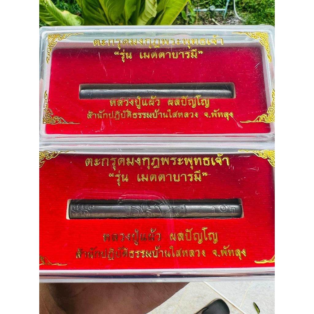 lead takrut blessed by Luang Pu Paew displayed in red velvet presentation boxes with gold Thai script