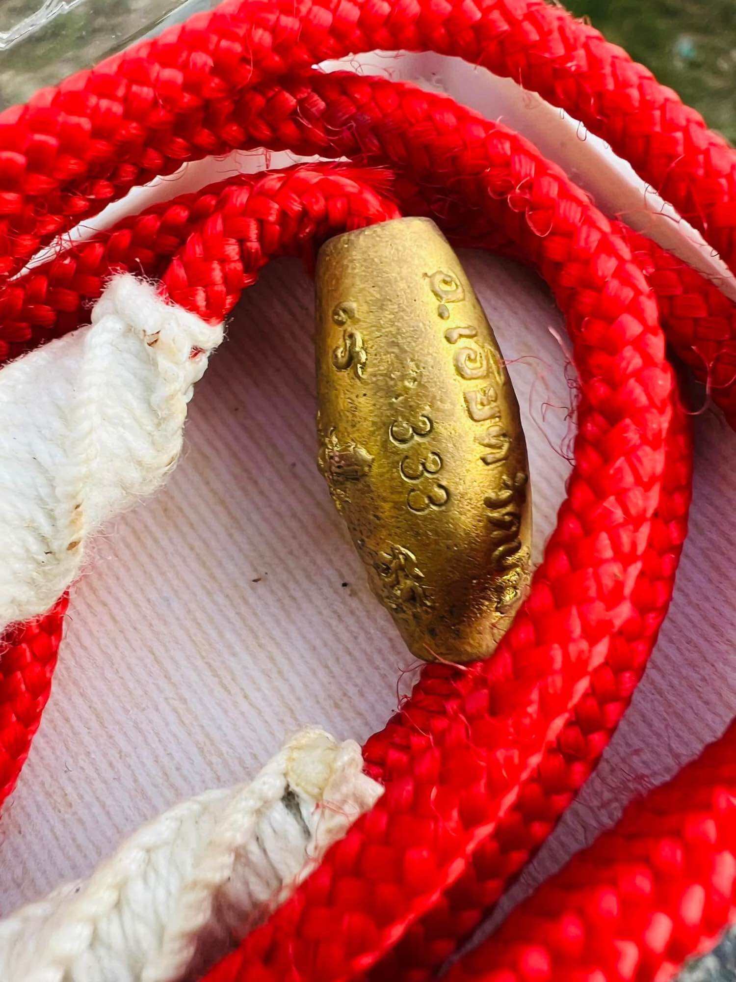 Limited edition Thai Takrut with Luk Sakot beads. Gold takrut amulet with Thai script on red braided cord and white knots