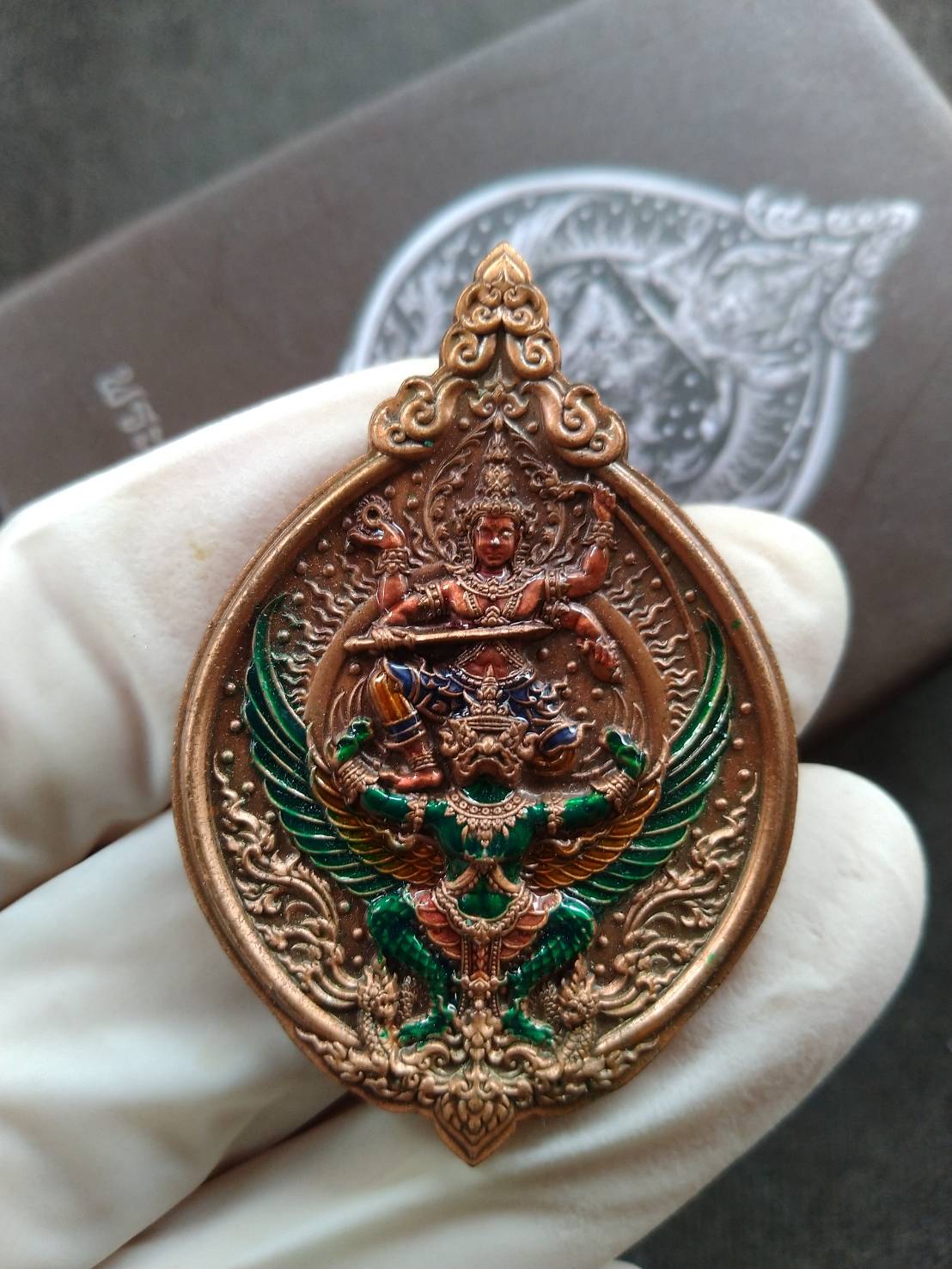 Thai Blessing Co Lord Narai on Garuda amulet copper finish with green enamel detailing held in gloved hand