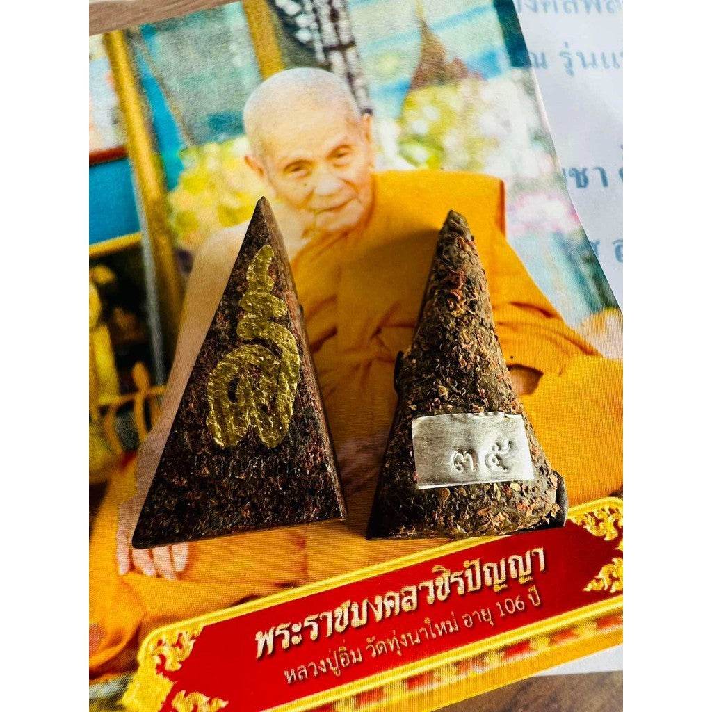 Luang Pu Im ploughshare amulet two triangular talismans with gold and silver markings before monk photo