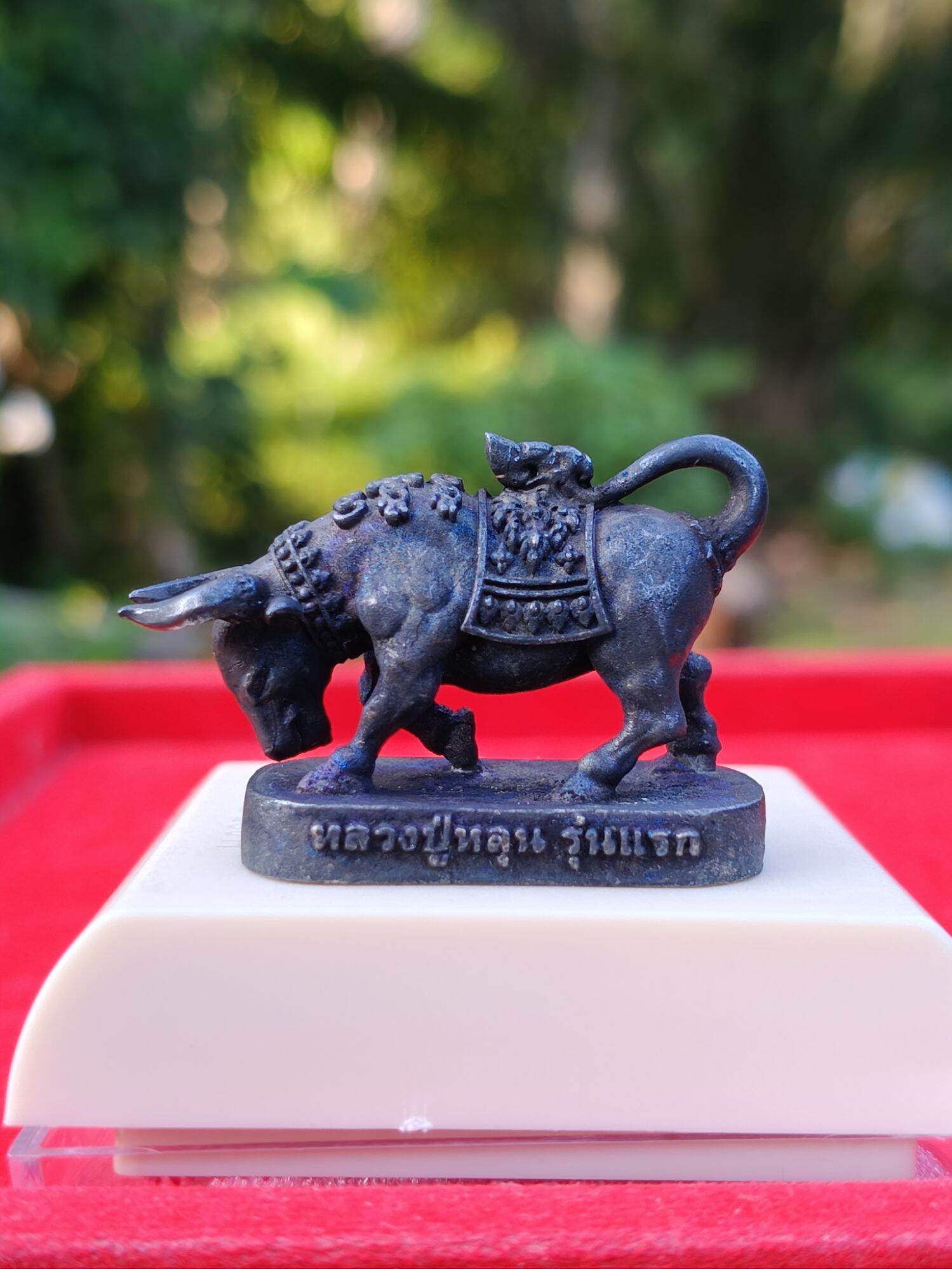 Luang Pu Lun buffalo charm for luck metal buffalo amulet on pedestal with Thai inscription by Thai Blessing Co