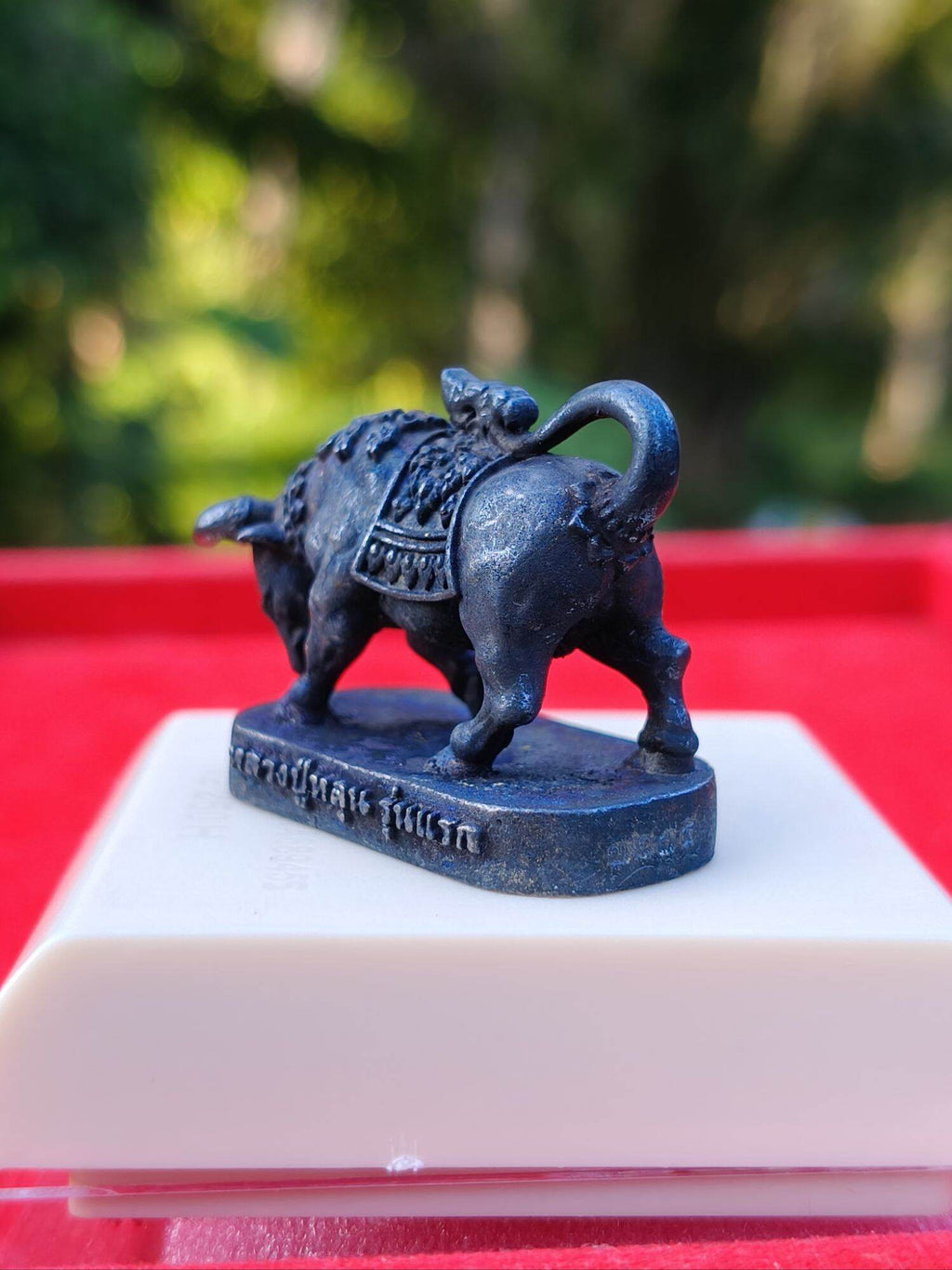 Luang Pu Lun buffalo charm for luck dark metal miniature pendant on pedestal with Thai script base