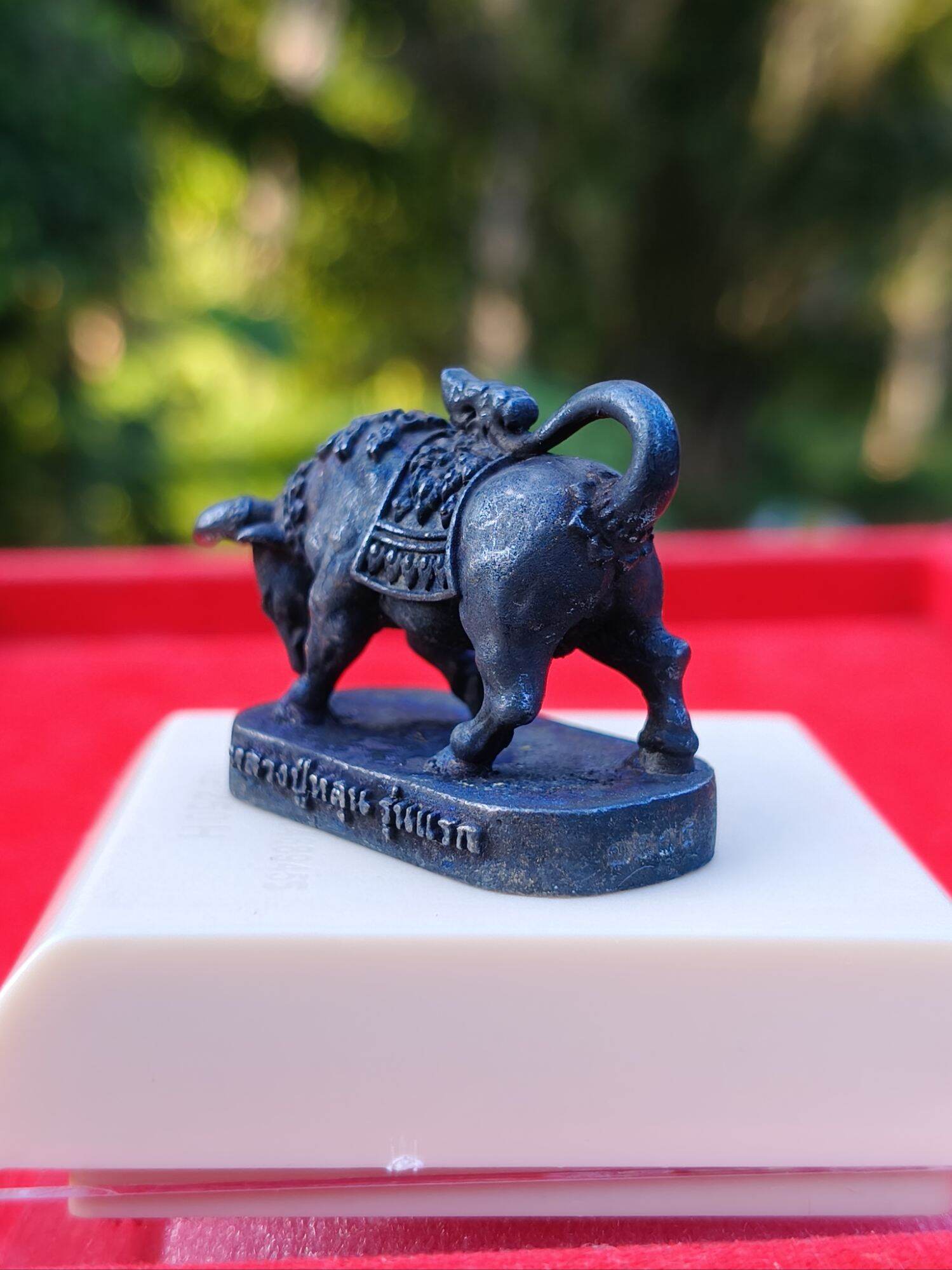 Luang Pu Lun buffalo charm for luck dark metal miniature pendant on pedestal with Thai script base