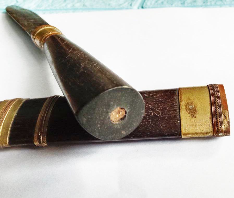Luang Pu Moon ritual knife with dark wooden handle and brass scabbard fittings on white background close up
