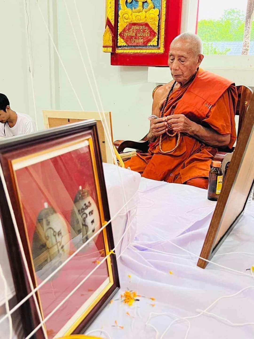 Luuk Sawat sacred charm framed amulet pictured during monk blessing ceremony with prayer beads