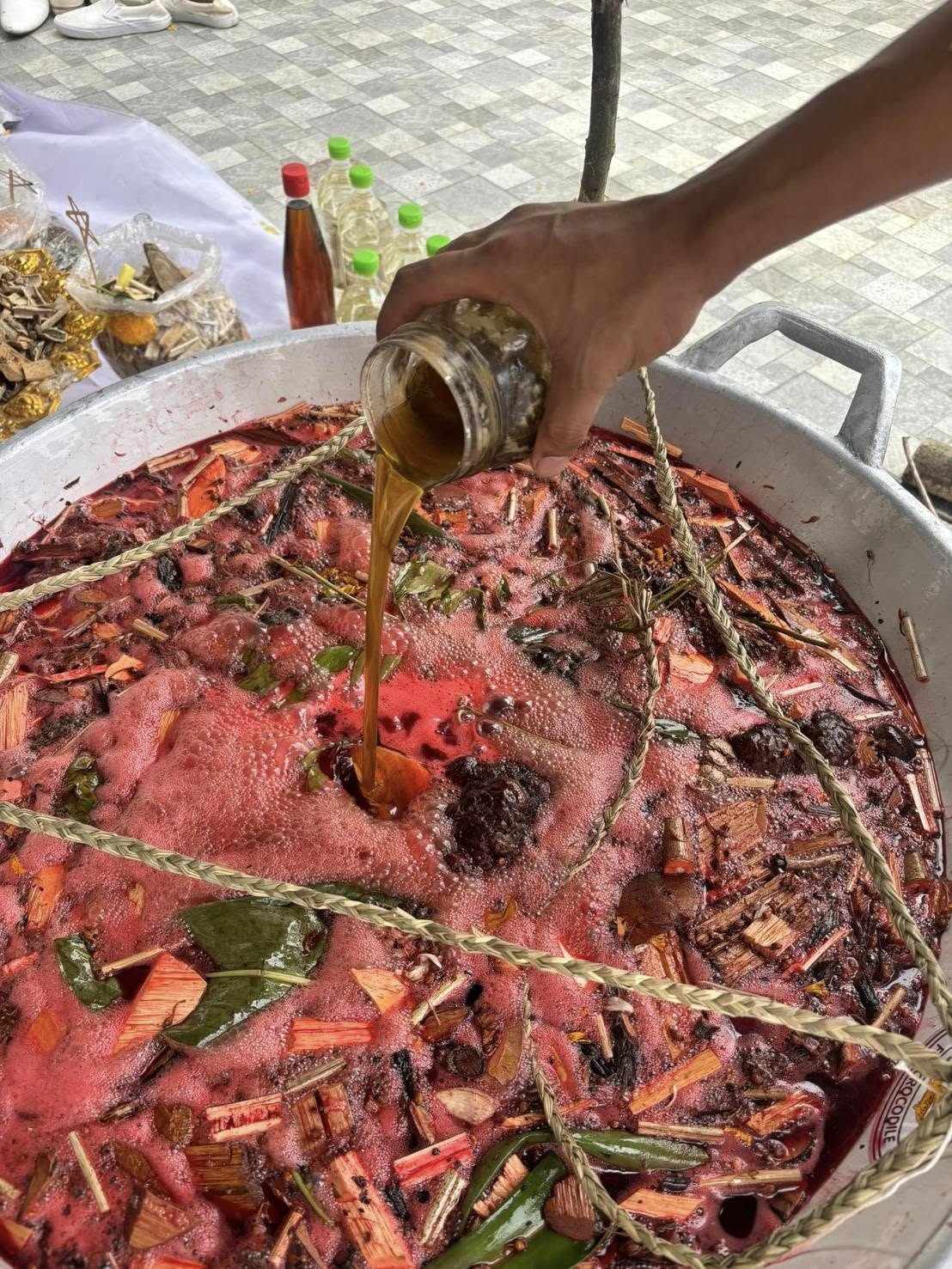 Thai Blessing Co Luuk Sawat sacred charm herbal blessing ritual pot with boiling herbs and pouring oil