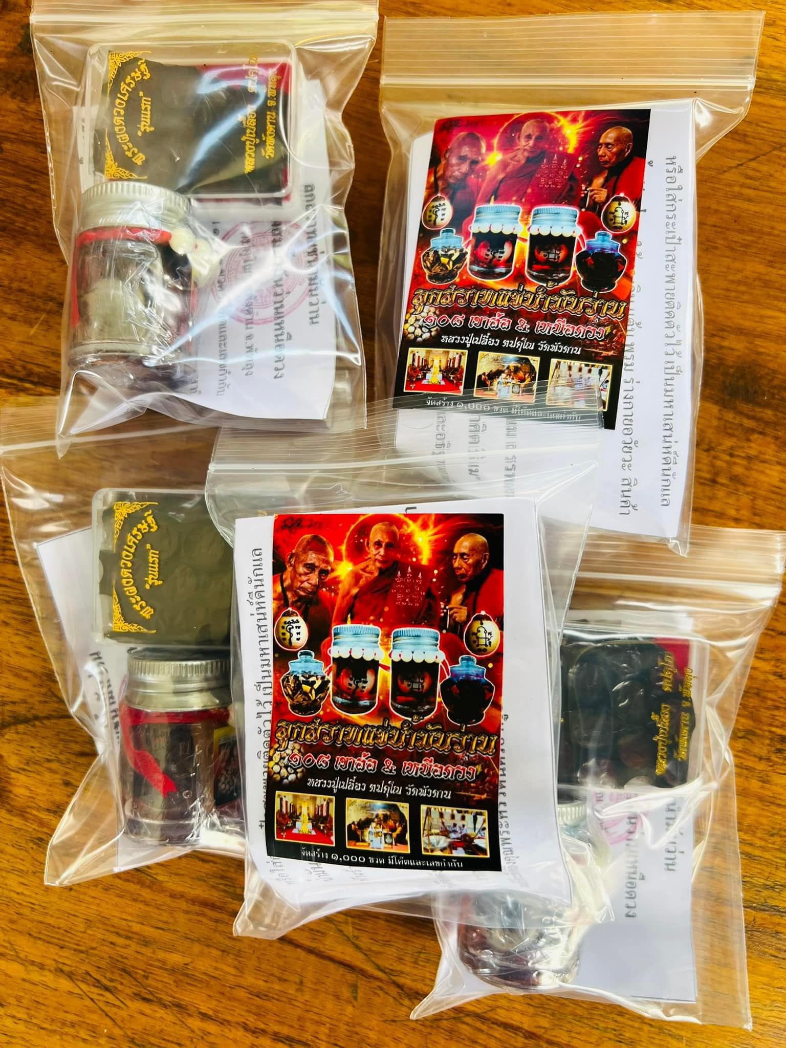 Four packaged Luuk Sawat sacred charm amulet sets in clear zip bags with labels small glass jars and instruction sheets