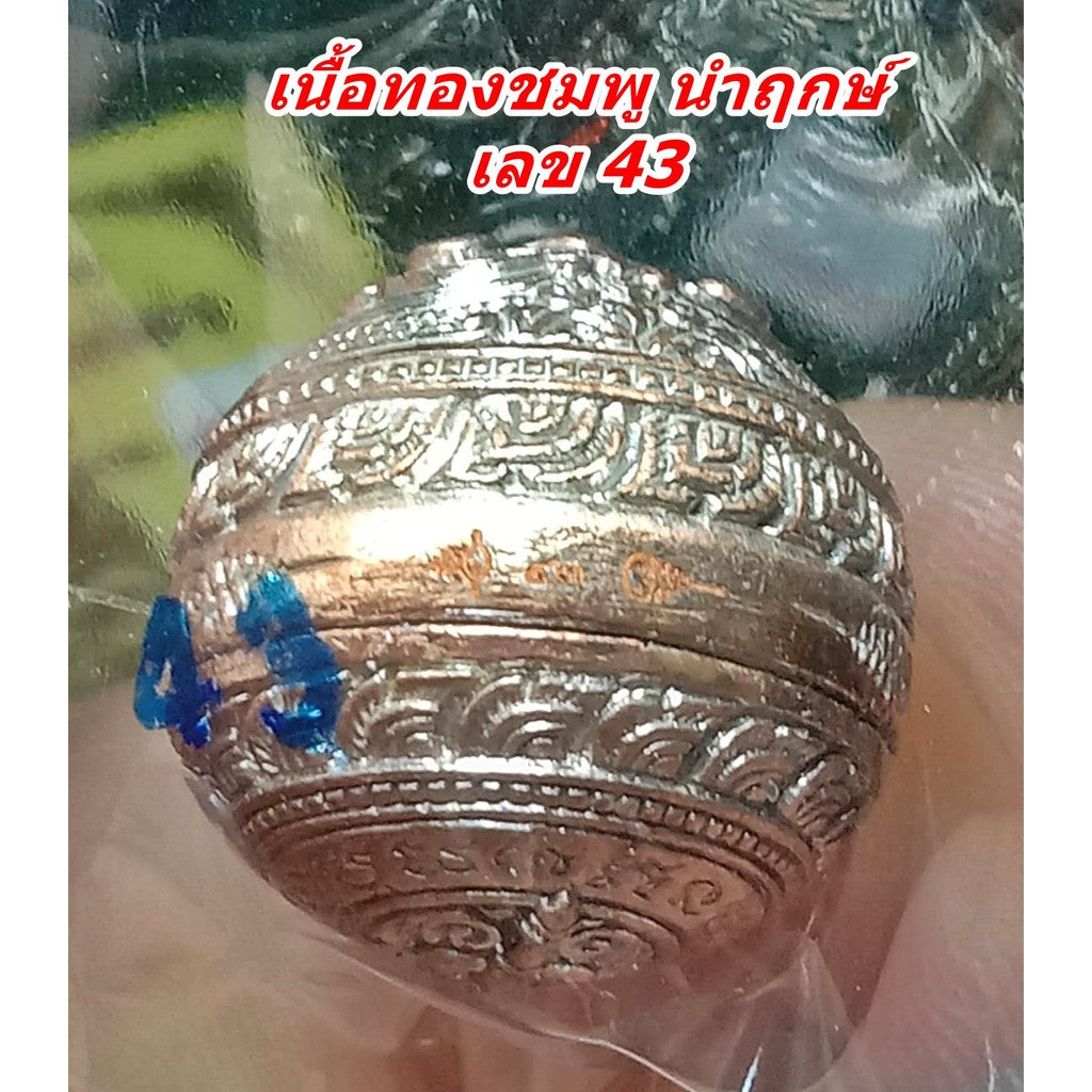 Close up of engraved pink gold amulet bead marked 43 with blue ink by Thai Blessing Co Mercury Hor Twin Rahu amulet for wealth.