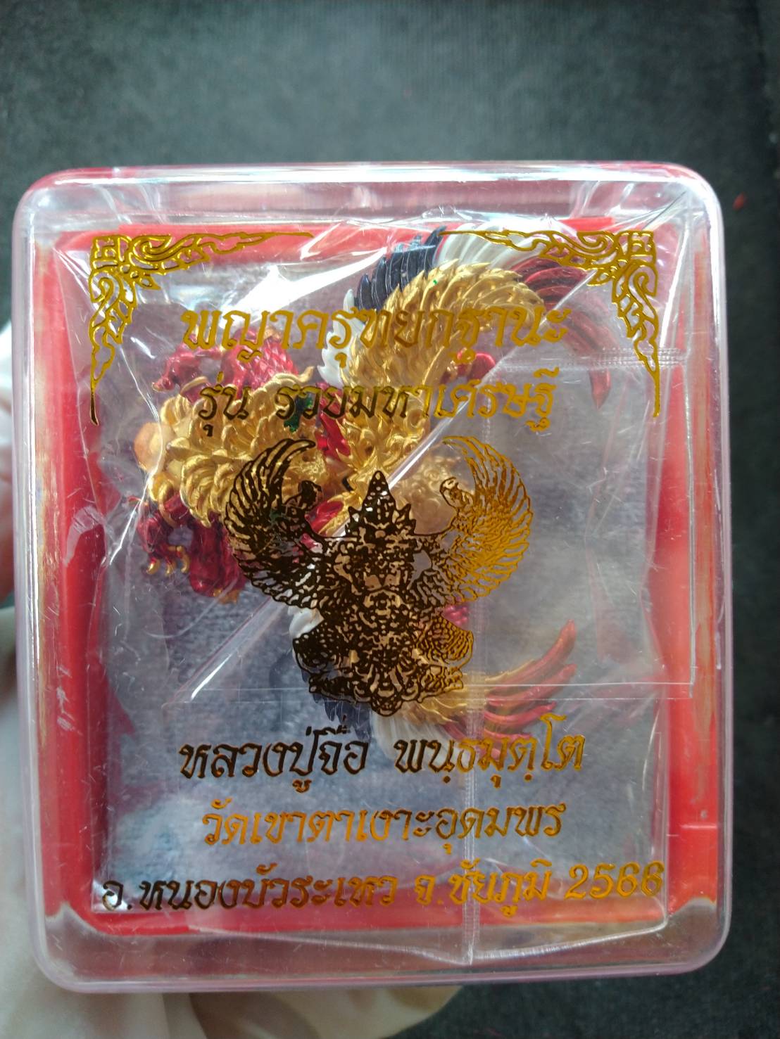 Phaya Garuda amulet for wealth in clear plastic display box with gold print red base and braided cord