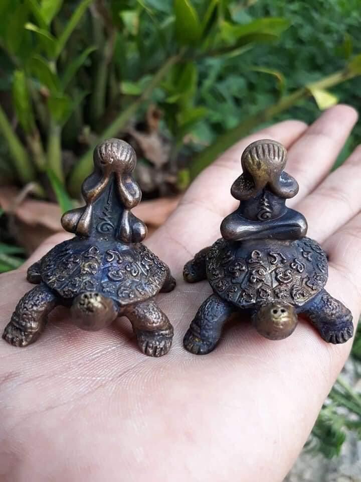 Phaya Tao Reuan amulet for wealth small bronze turtle statues with meditating monk figures held in palm