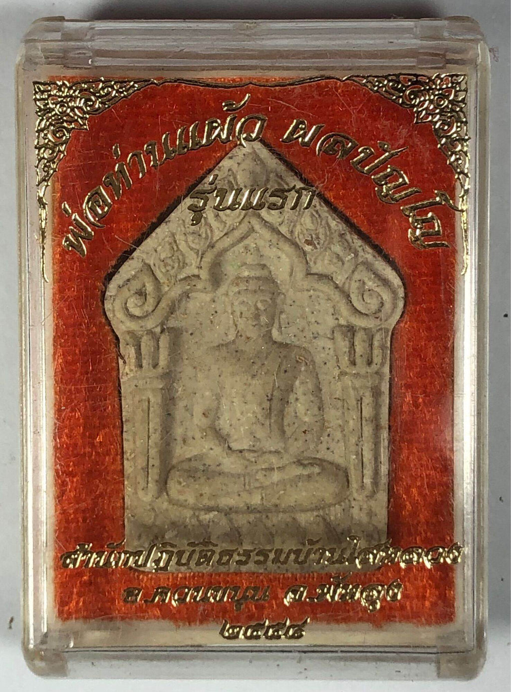 Phra Khun Paen Phlai Kumarn Amulet in clear plastic case showing seated Buddha amulet with red gold Thai label