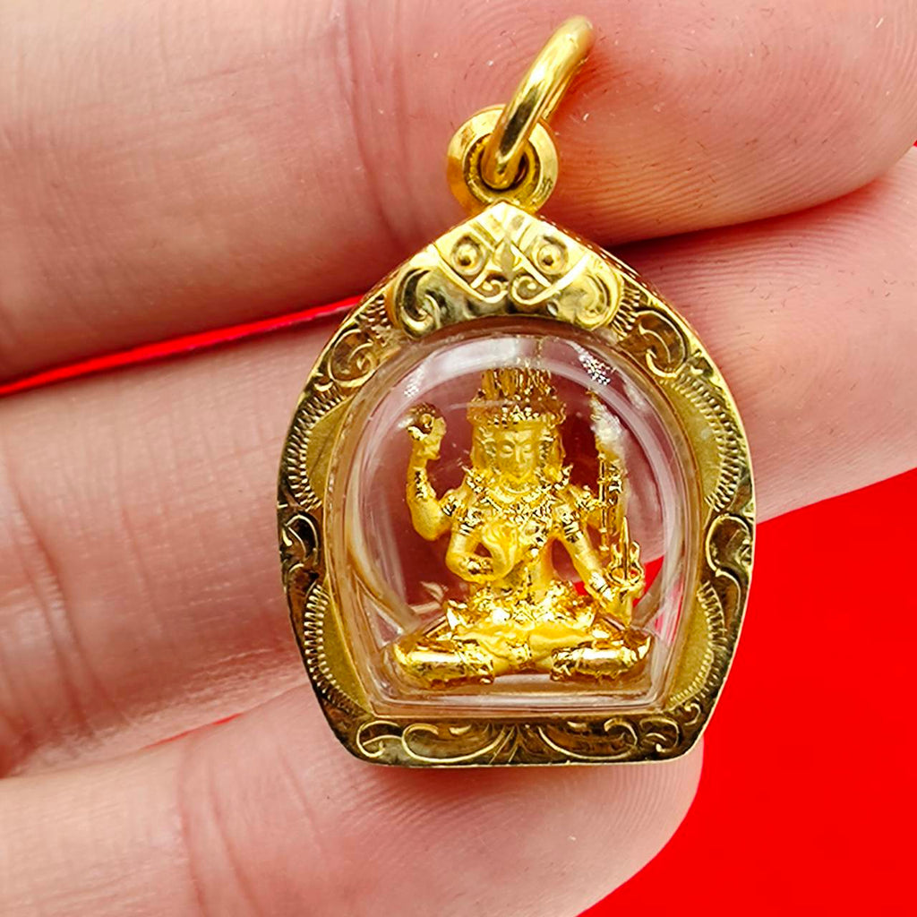 Phra Phrom amulet gold case ornate gold miniature deity in clear dome pendant held between fingers