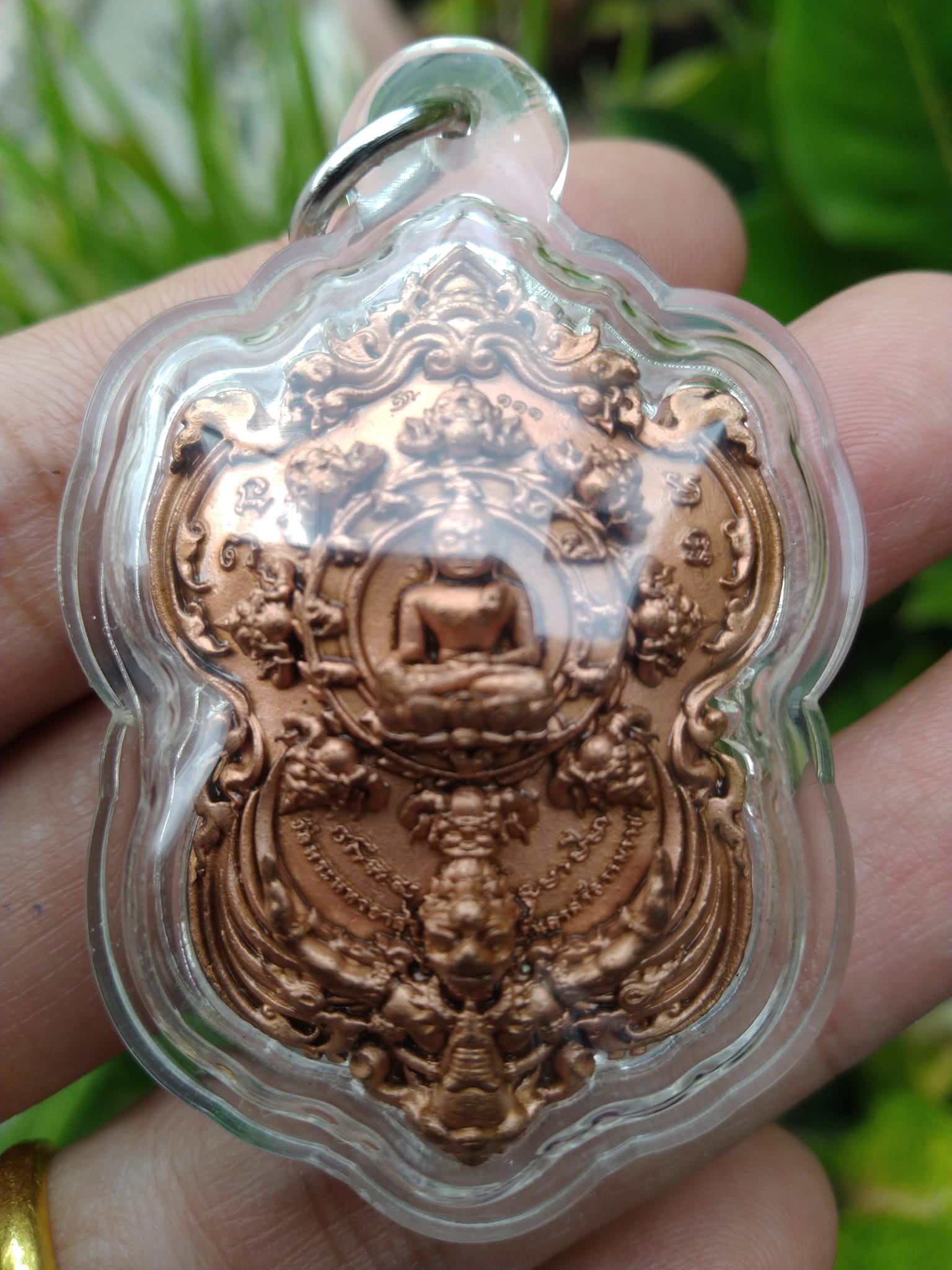 Thai Blessing Co copper Phra Pidta amulet for wealth in clear protective casing with embossed Buddha design
