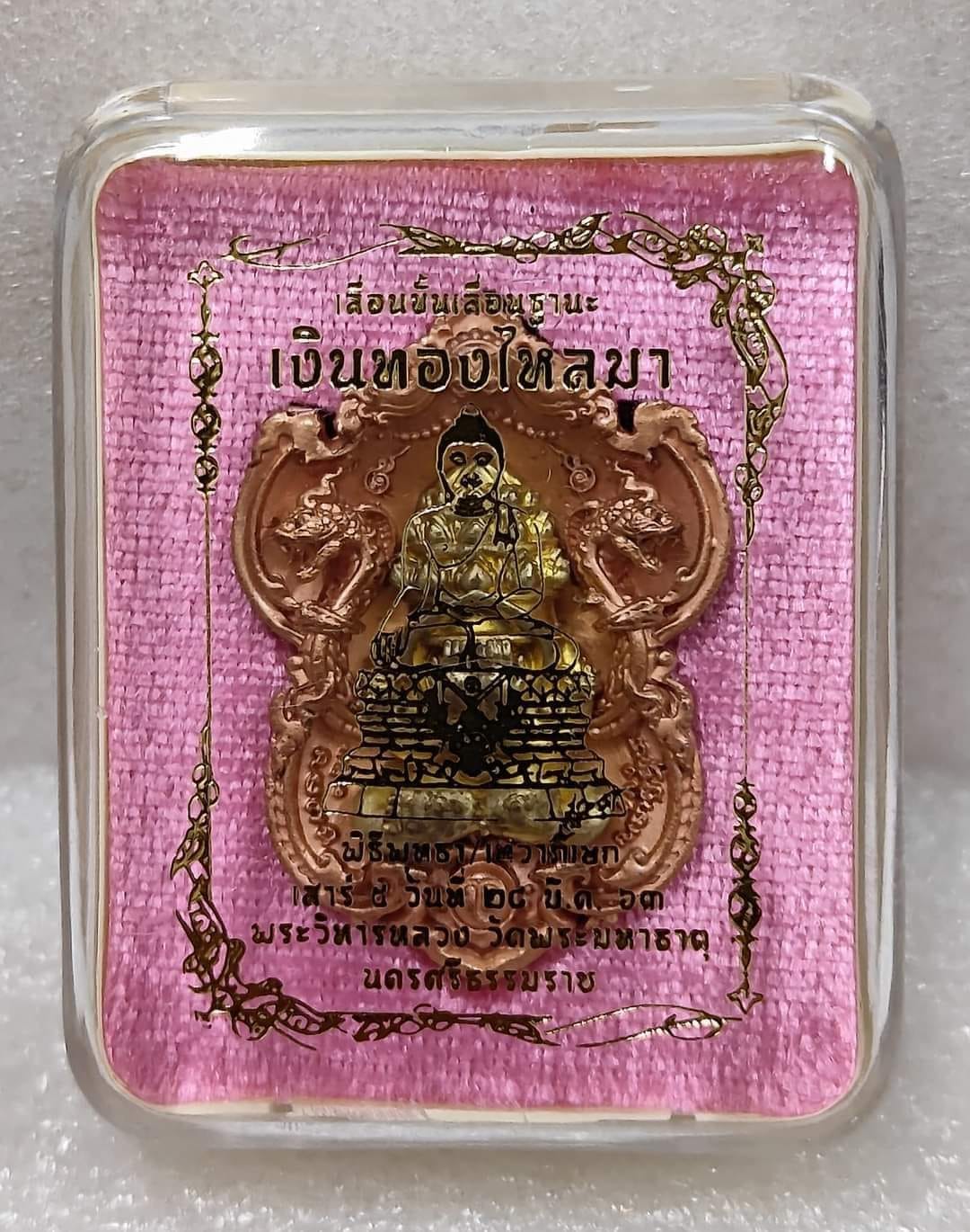Phra Pidta amulet for wealth copper pendant in clear display case on pink fabric by Thai Blessing Co