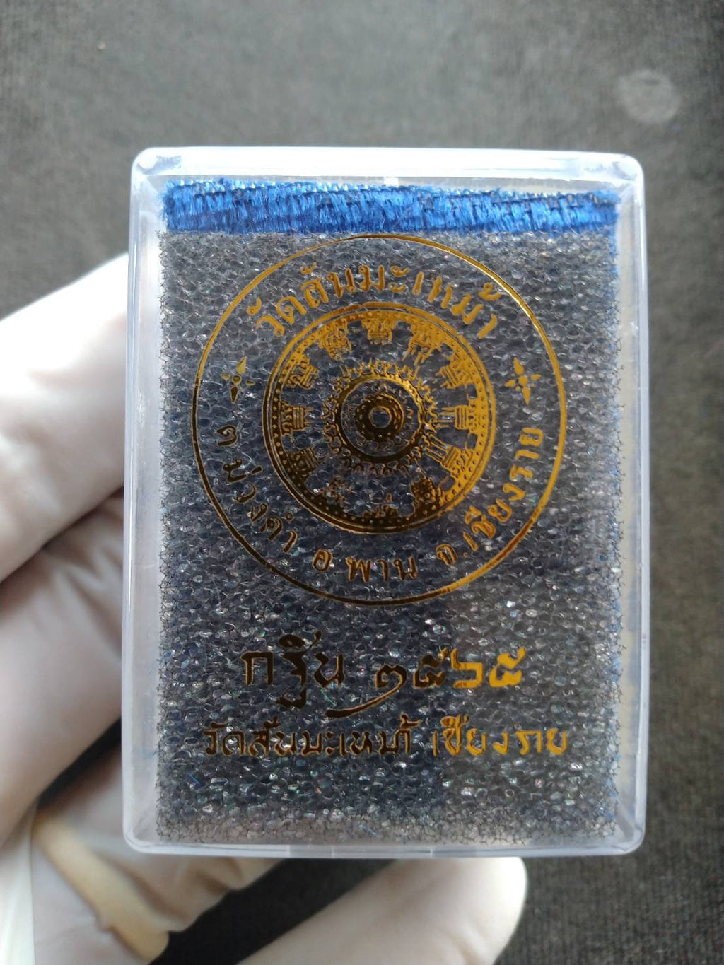 Phra Taow Wessuwan amulet for wealth in clear plastic case with foam insert and gold Thai emblem