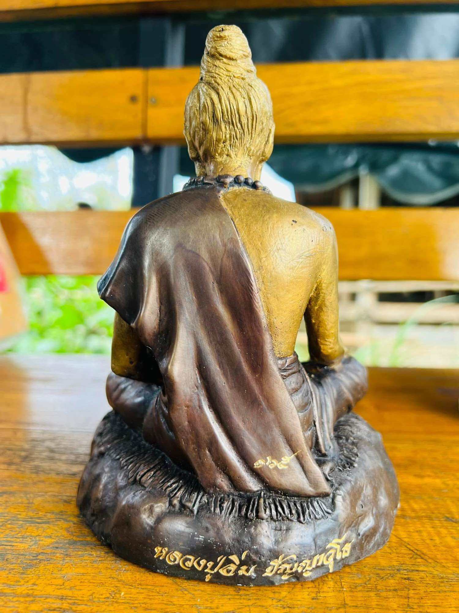 Phu Lersi Jivaka Komarabhacca statue seated meditating figure in gold and brown robe back view decorative amulet for home altar