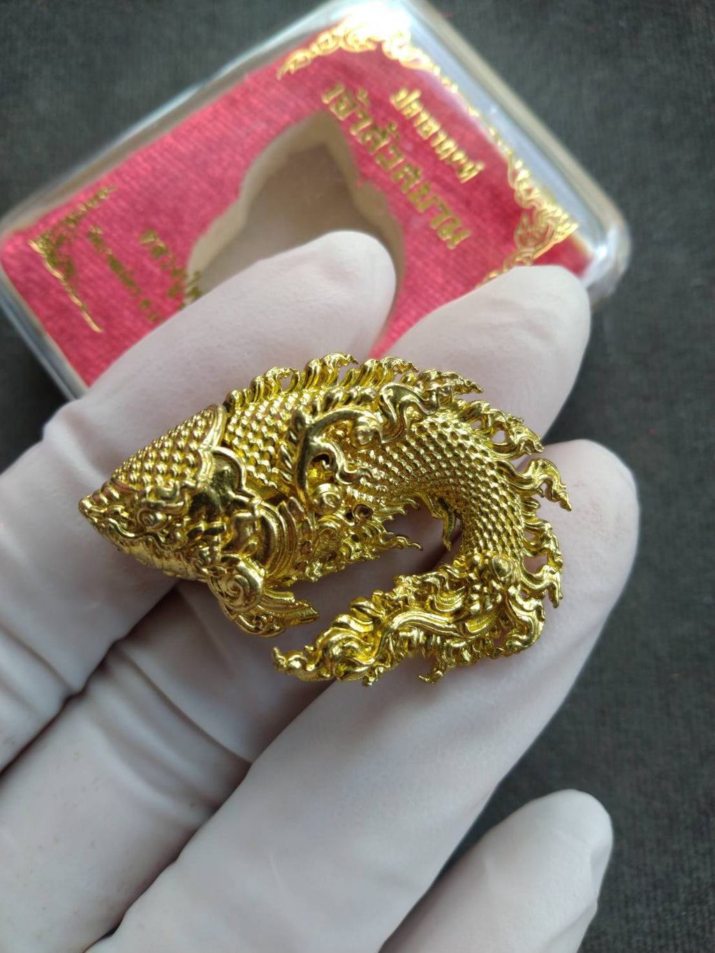 Pla Anon Chao Sua Siam amulet for wealth ornate gold fish pendant with intricate Thai motifs held in white glove