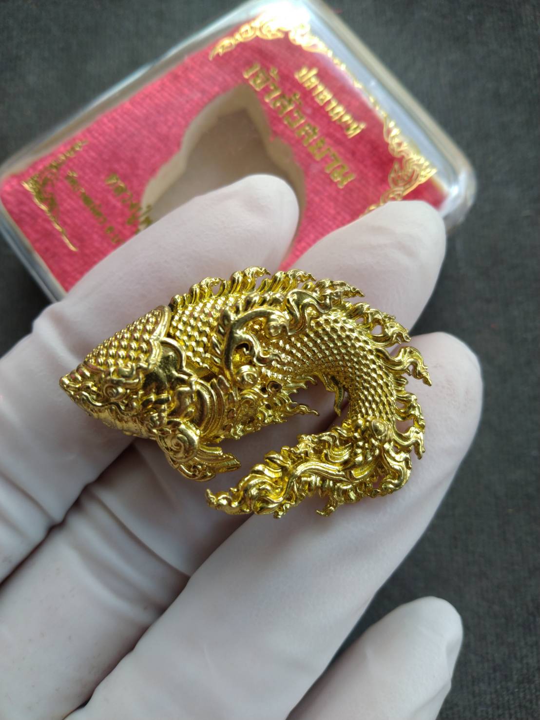 Pla Anon Chao Sua Siam amulet for wealth ornate gold fish pendant with intricate Thai motifs held in white glove