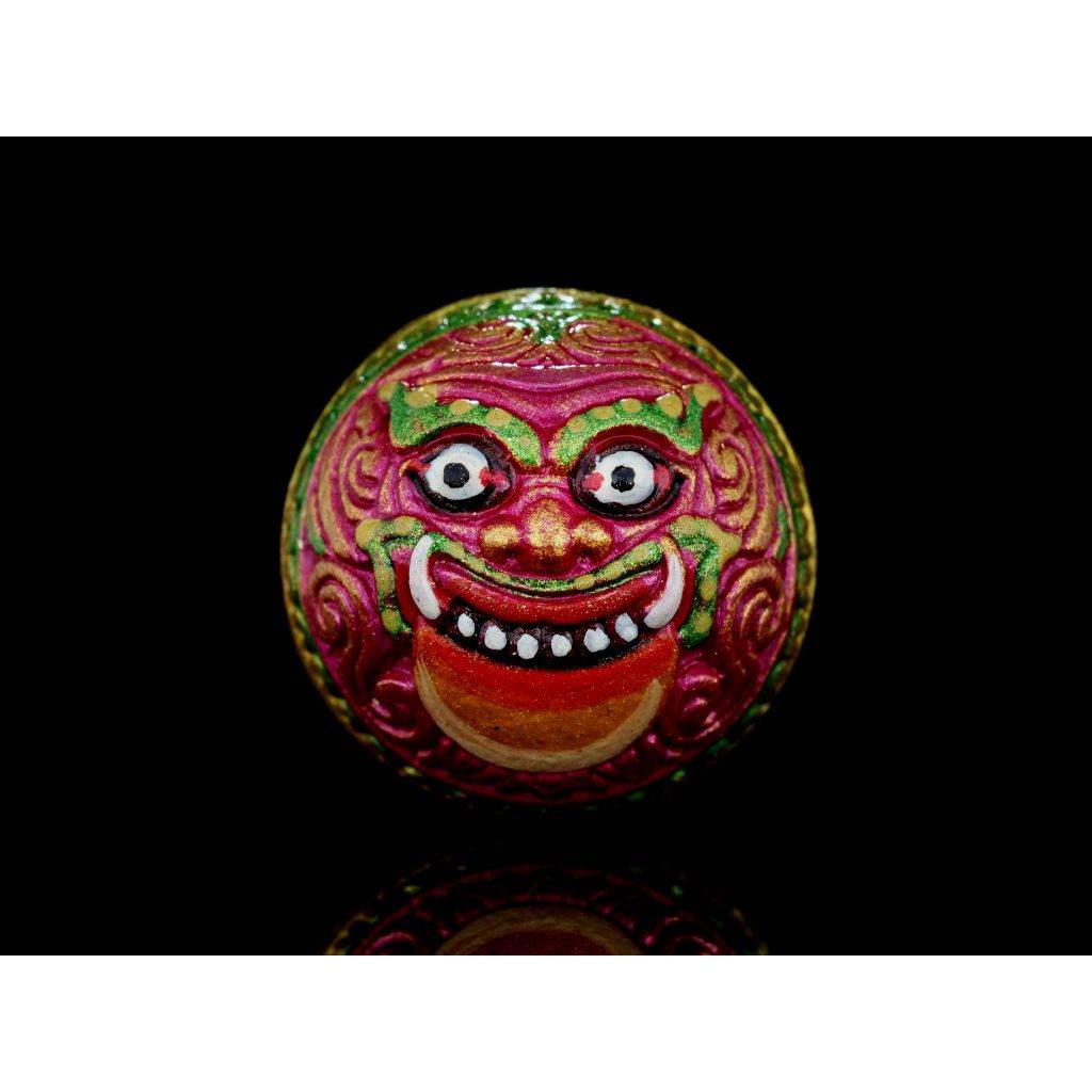 Rahu Amulet round painted talisman with vivid pink green gold demon face on black background