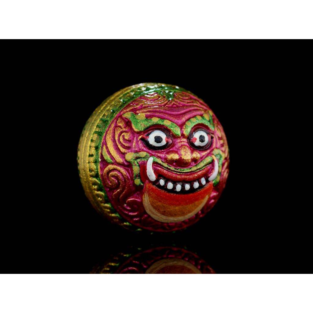 Colorful round Rahu Amulet with demon face in pink green and gold for protective home feng shui decor