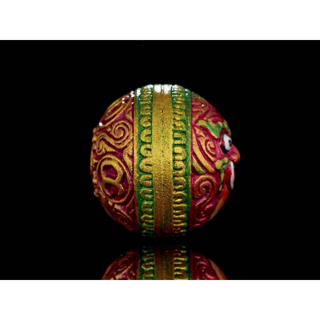 Rahu Amulet decorative round talisman bead in red green and gold with ornate carved face for feng shui and reflection