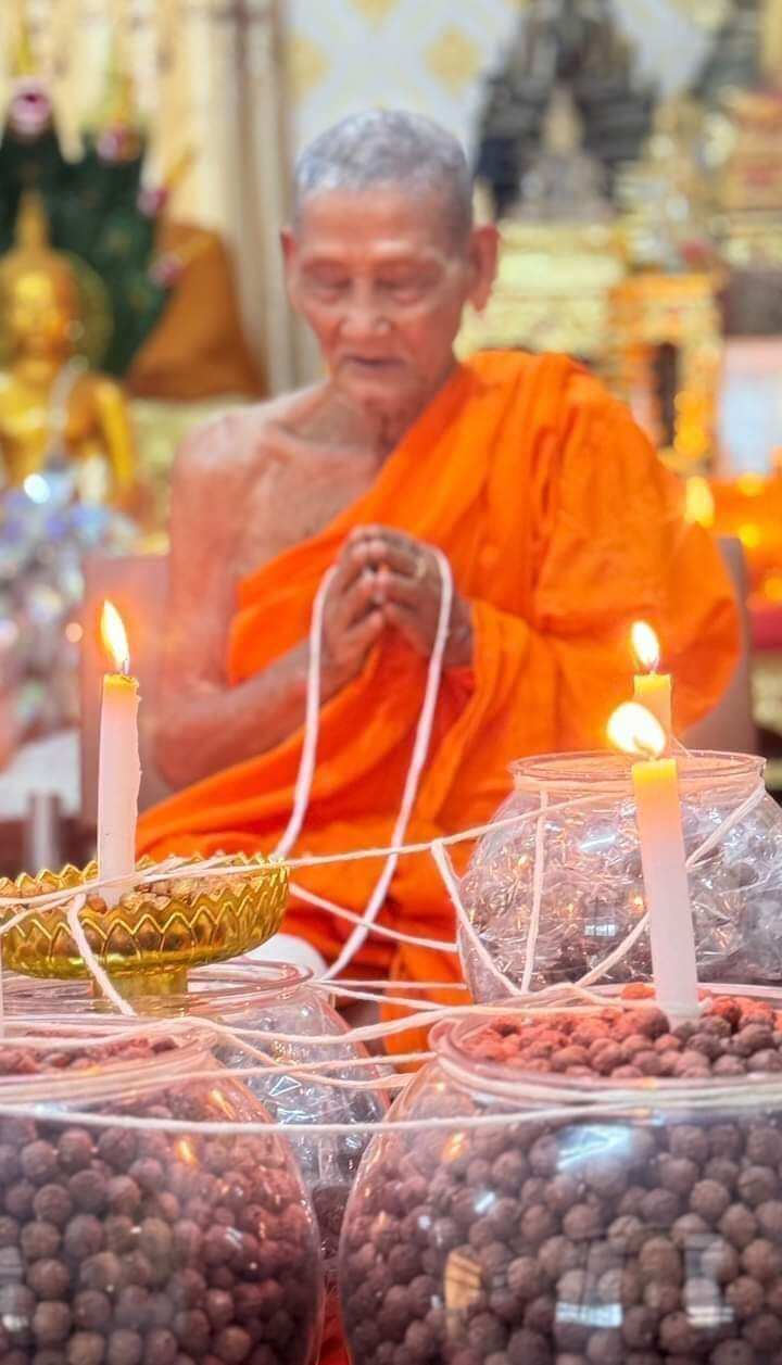 Thai monk blessing jars of Rahu Garuda mercury talisman ball amulets with candles and prayer threads by Thai Blessing Co