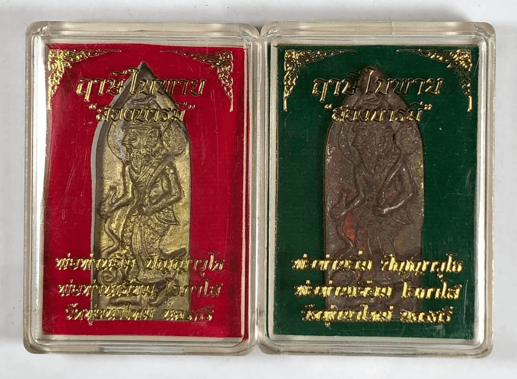 Two Ruesi Bai Pai amulet for protection in clear plastic cases with red and green velvet backings and gold script