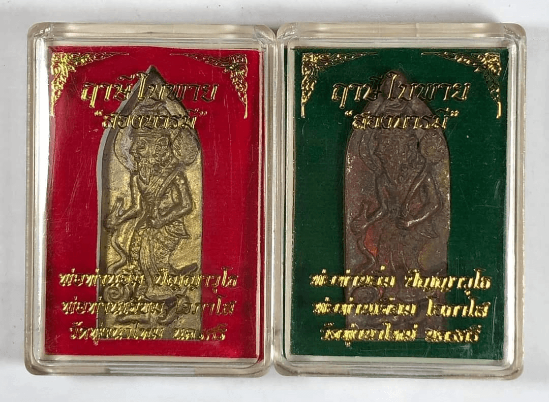 Two Ruesi Bai Pai amulet for protection in clear plastic cases with red and green velvet backings and gold script