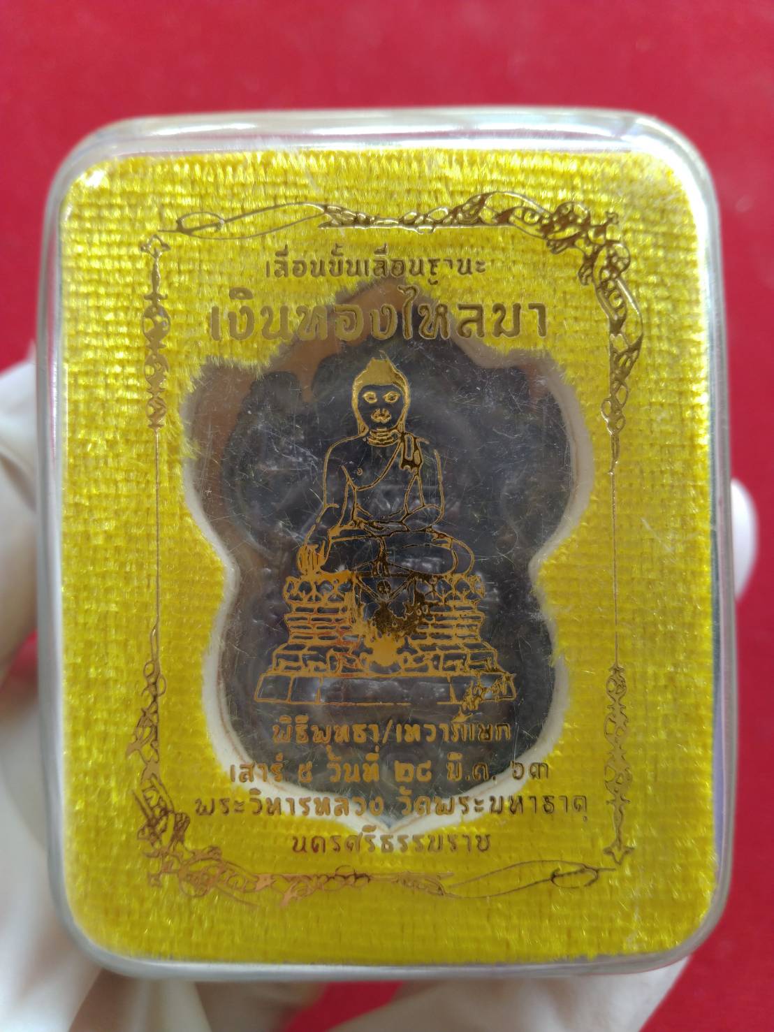 Si Maharaj Phangpakal rattle amulet pendant in clear plastic case with yellow fabric backing and printed monk image
