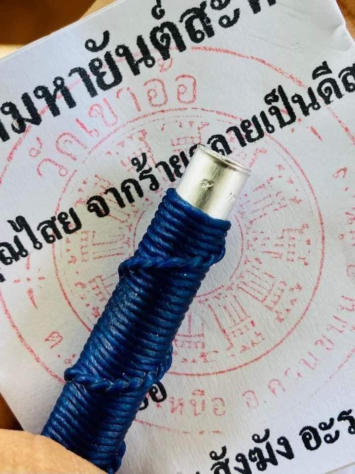 Thai Blessing Co takrud to reflect negative energy amulet cylinder wrapped in blue cord on yantra paper