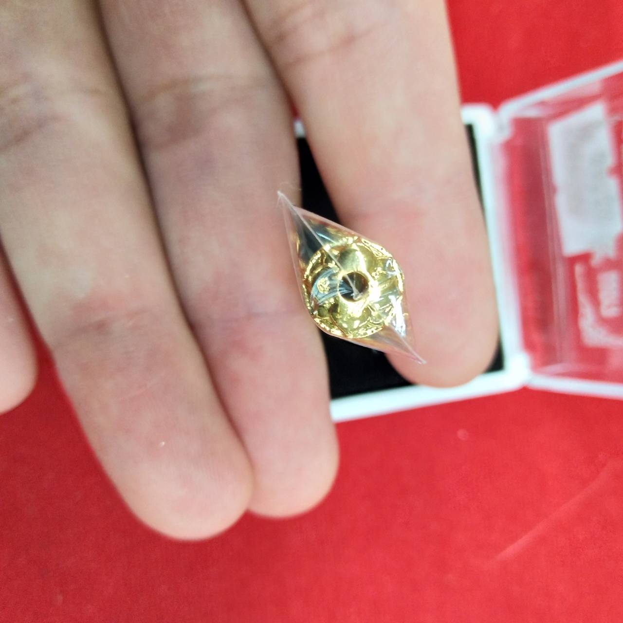 Thai Blessing Co takrut 5 lines amulet small gold cone wrapped in plastic held between fingers
