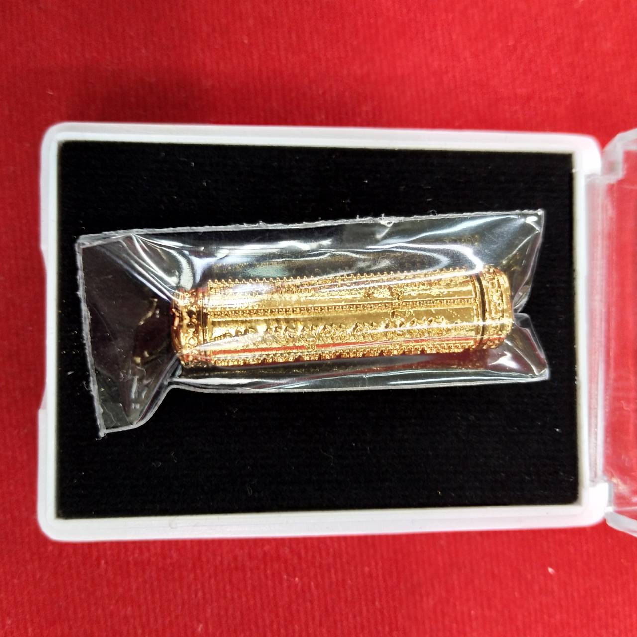 Thai Blessing Co takrut 5 lines amulet gold engraved cylinder in clear plastic pouch on black presentation tray