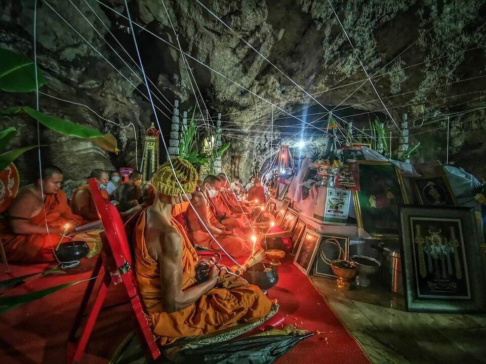 Tao Wessuwan Amulet - Vann Material, Blessed by 12 Esteemed Monks . Monks in cave performing candle ritual blessing amulets