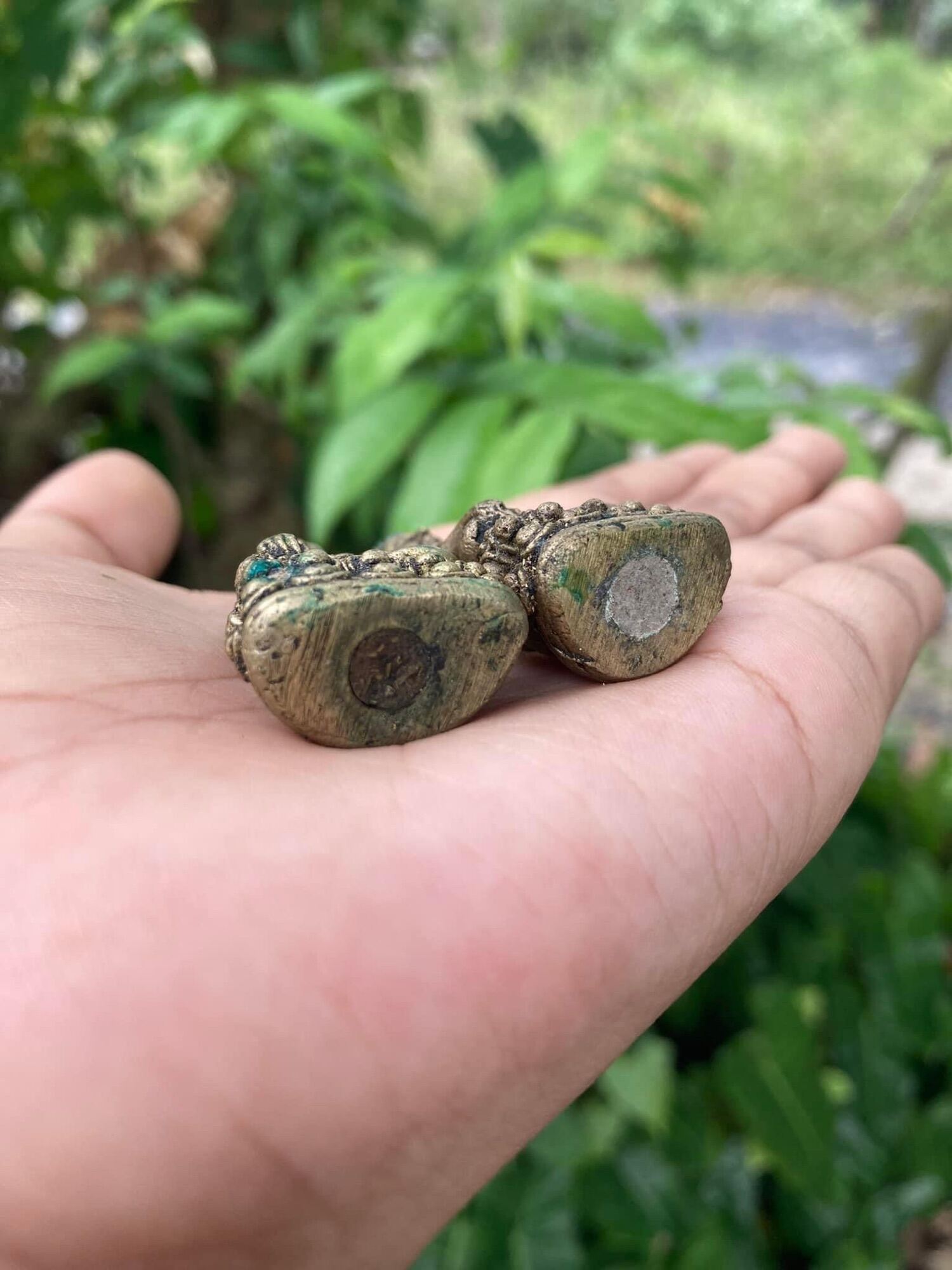 Thai Blessing Co aged bronze figurine pair in palm with patina and inlay Thai ghost-repelling amulet for protection.