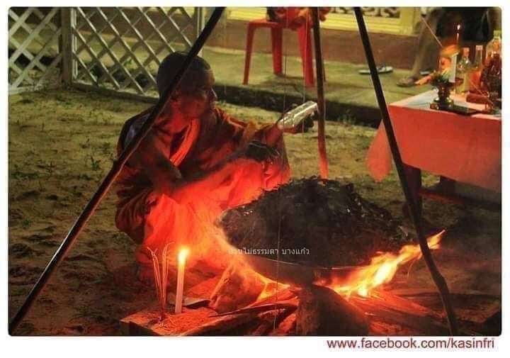 Thai ghost-repelling amulet for protection displayed with a robed figure performing a nighttime ritual by fire and altar offerings