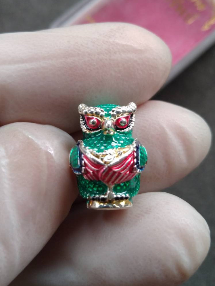 Thai Blessing Co green enamel owl pendant amulet held between fingers Thevarattikan Wealth Embracing Deity .