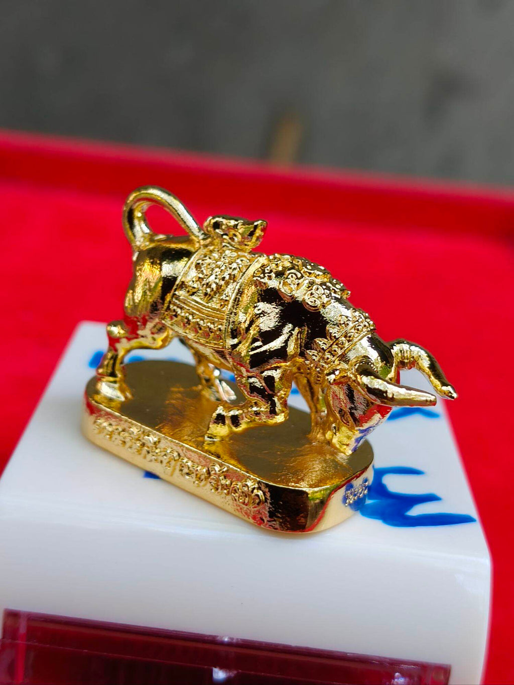 Wua Ta Nhoo sacred bull talisman gold miniature ornate Thai amulet on display pedestal by Thai Blessing Co