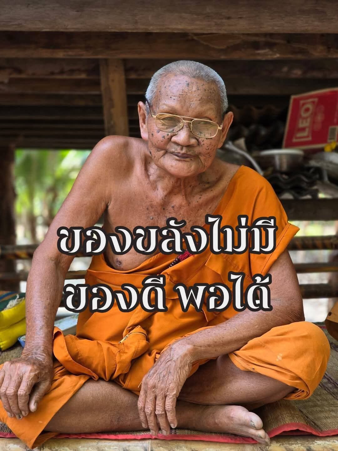 Elder Thai Buddhist monk in orange robe with Wua Ta Nhoo sacred bull talisman pendant by Thai Blessing Co