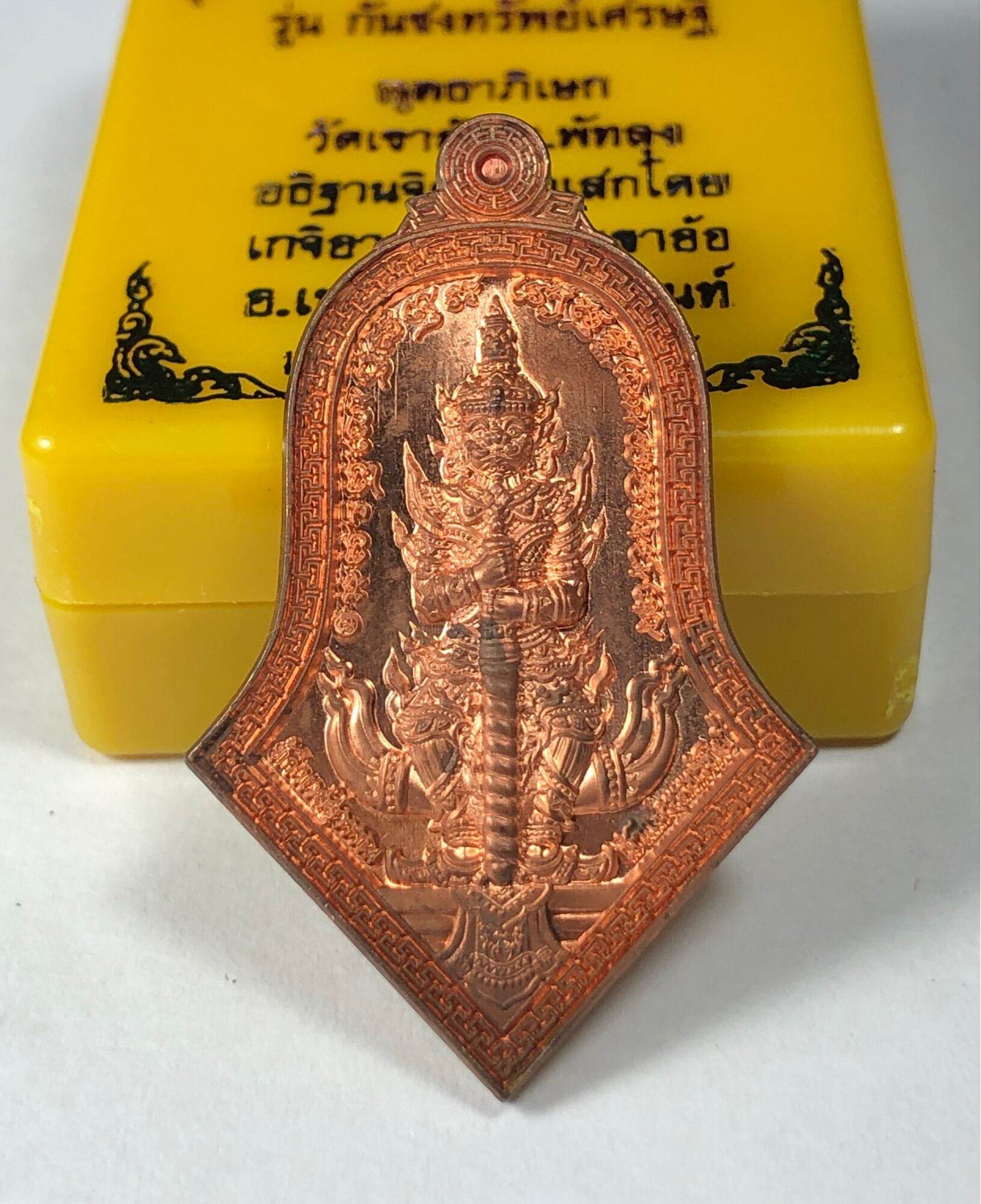 Phaya Wes Suwan coin amulet copper pendant showing detailed guardian deity relief on yellow box